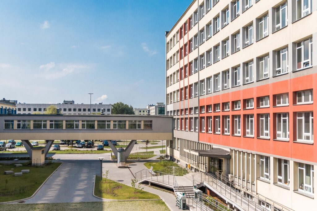 En modern skolbyggnad med flera våningar, fönster och en gångbro mellan byggnader.