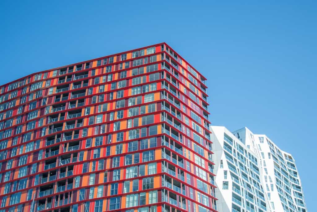 Modern kontorsbyggnad med glasfasad mot blå himmel.