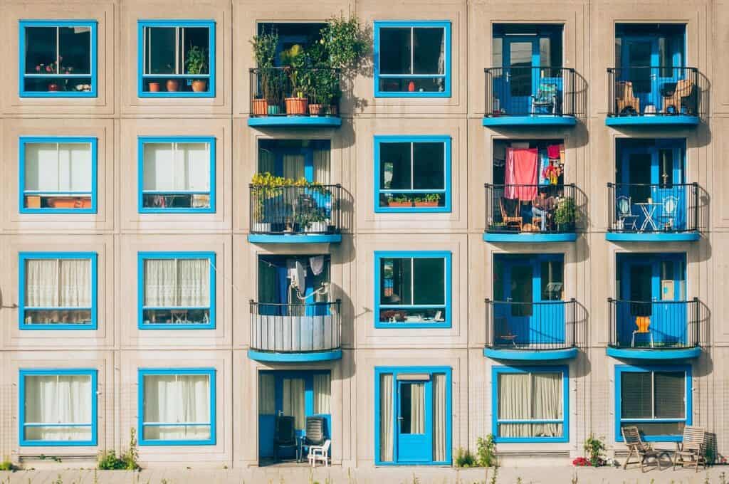 Flerbostadshus med många fönster och balkonger i fasaden.