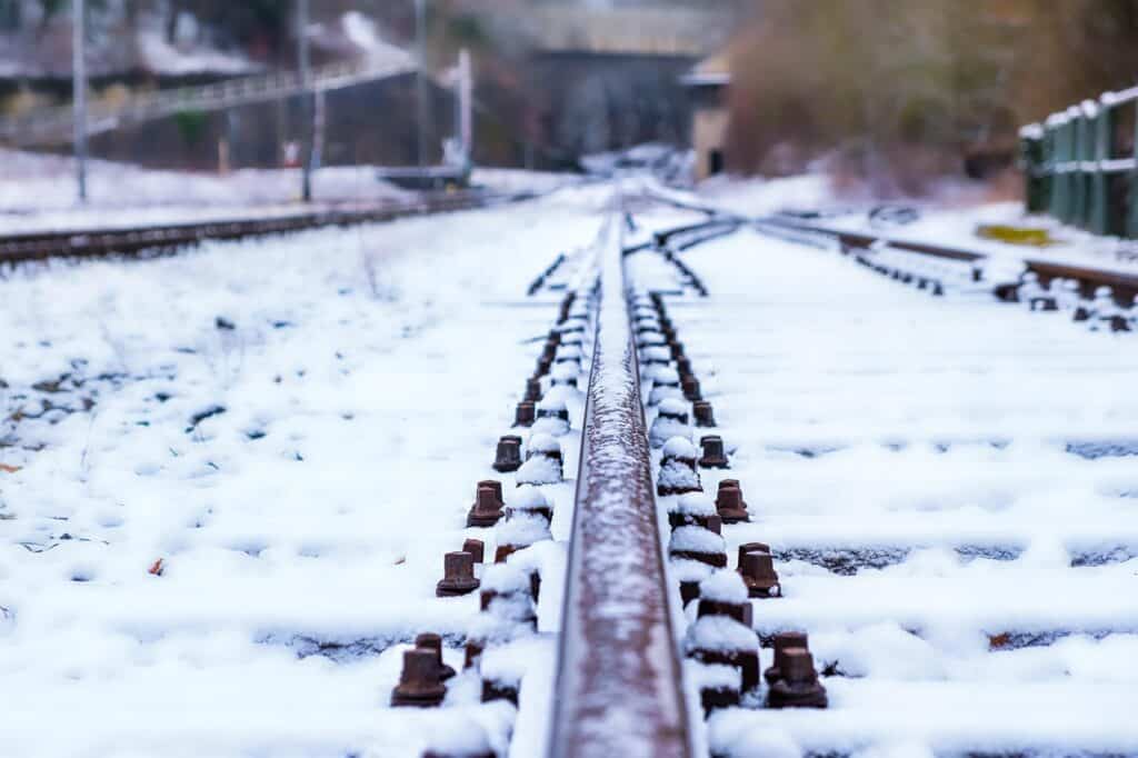 Snötäckta järnvägsspår med rostiga växlar och spårdetaljer i vinterlandskap.
